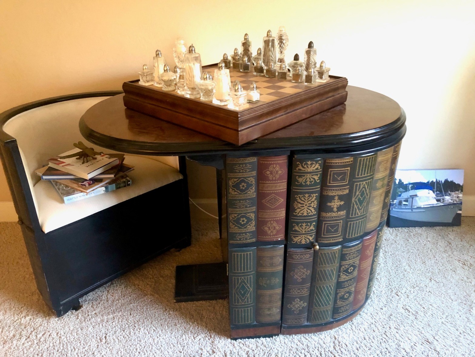 A custom table that looks like a bookcase. A salt and pepper shaker chess set is on top of it.