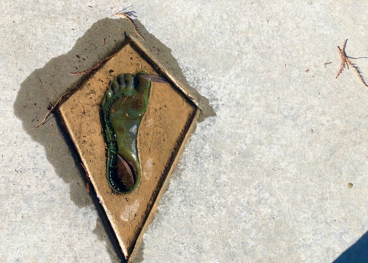 Bronze footprint embedded in a sidewalk