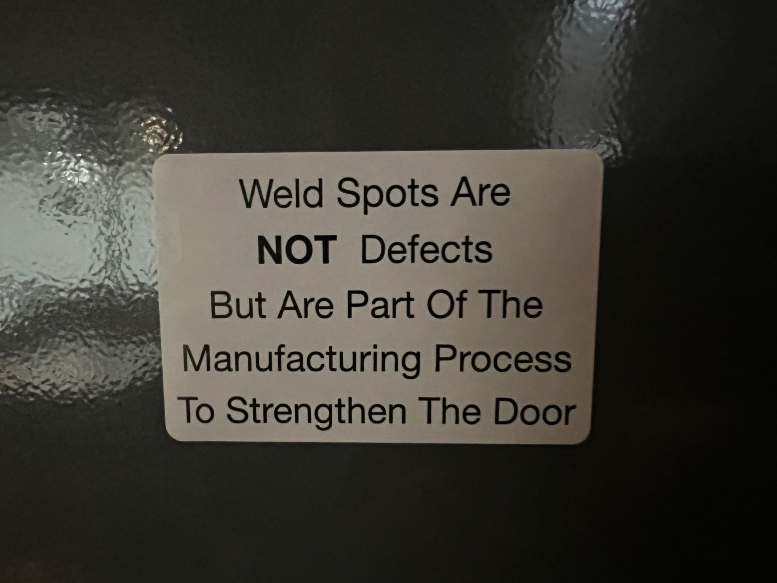 Sign on a new cabinet that says Weld Spots Are Not Defects